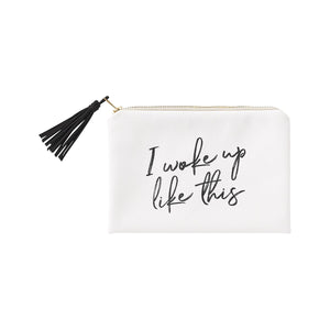 White cosmetic bag with a black tassel zipper pull and the words "I Woke Up Like This" imprinted on the front. 