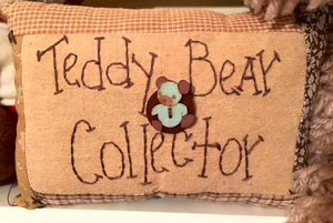 small quilted look decorative pillow with the words "Teddy Bear Collector" stitched on front as well as an adorable teddy bear button 